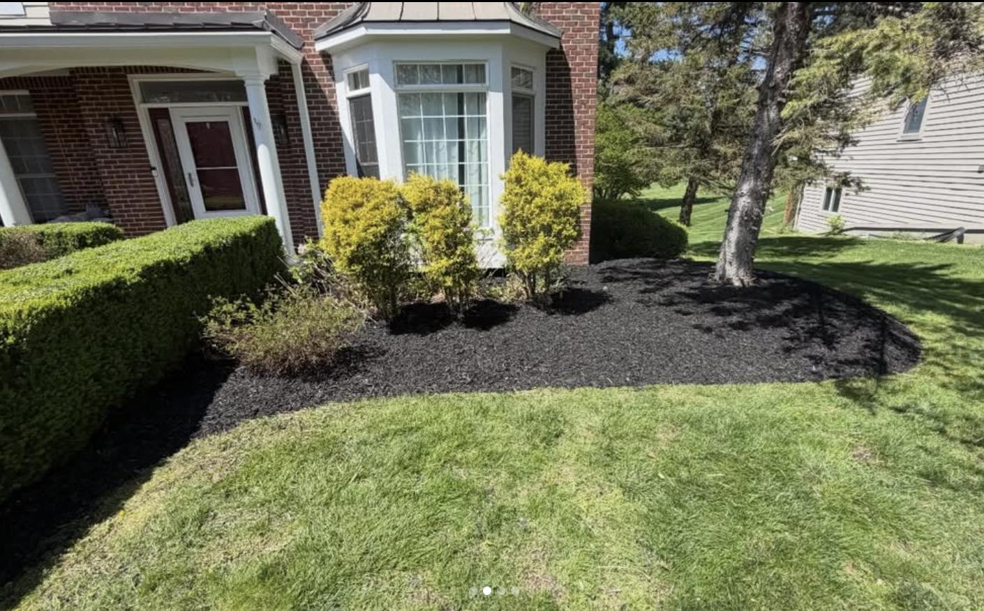Curved mulch bed installation around bay window